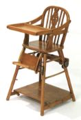A 20th century pine wheelback adaptable highchair.