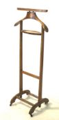 A mid-century wooden valet stand on wheels.