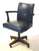 A mid-20th century swivel desk chair. Upholstered in blue vinyl, on oak support and casters, 87.