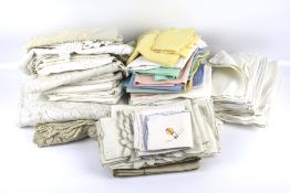 A large collection of assorted vintage table linen in various fabrics.