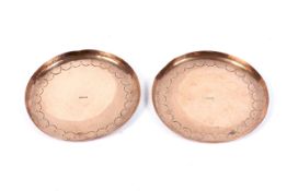 Two Newlyn Arts and Crafts copper coasters, circa 1900.