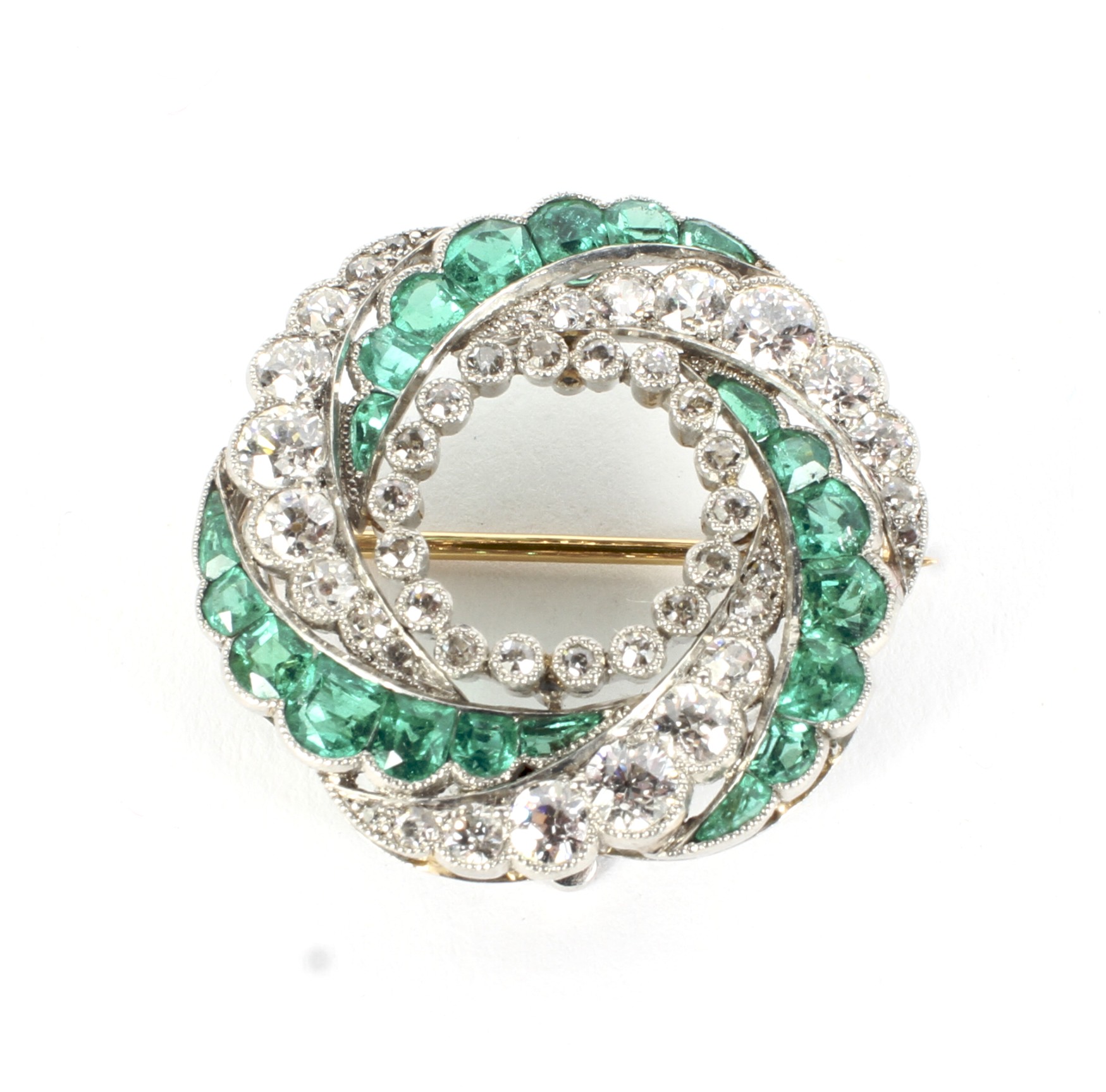 An early 20th century gold emerald and diamond spiral brooch/pendant.