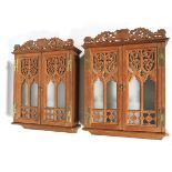 A pair of oak ecclesiastical wall mounted glazed cabinets.