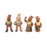 Four late 19th/early 20th century Continental terracotta gnomes in various poses. H27cm.