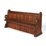 A late 19th century pitch pine church pew of unusual design, with cushion.