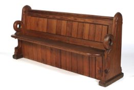 A late 19th century pitch pine church pew of unusual design, with cushion.