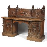 An early 20th century, heavily carved Continental pedestal sideboard.