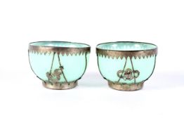 A small pair of early 20th century Chinese white metal mounted pale-green glass bowls.