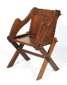 A 20th century carved oak Glastonbury elbow chair.