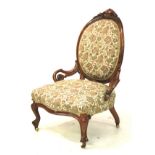 A Victorian walnut framed spoon back bedroom chair with pierced scrolled arms and overstuffed seat