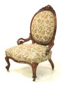 A Victorian walnut framed spoon back bedroom chair with pierced scrolled arms and overstuffed seat