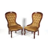 A pair of contemporary mahogany framed spoon button back nursing chairs.