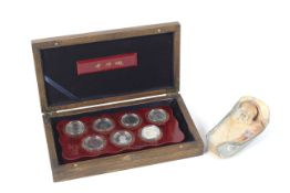 A cased set of 1990/2000s Chinese commemorative coins and a small carved soapstone boulder.