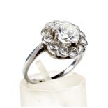 A mid-20th century platinum and diamond cluster ring. The central round brilliant approx. 1.