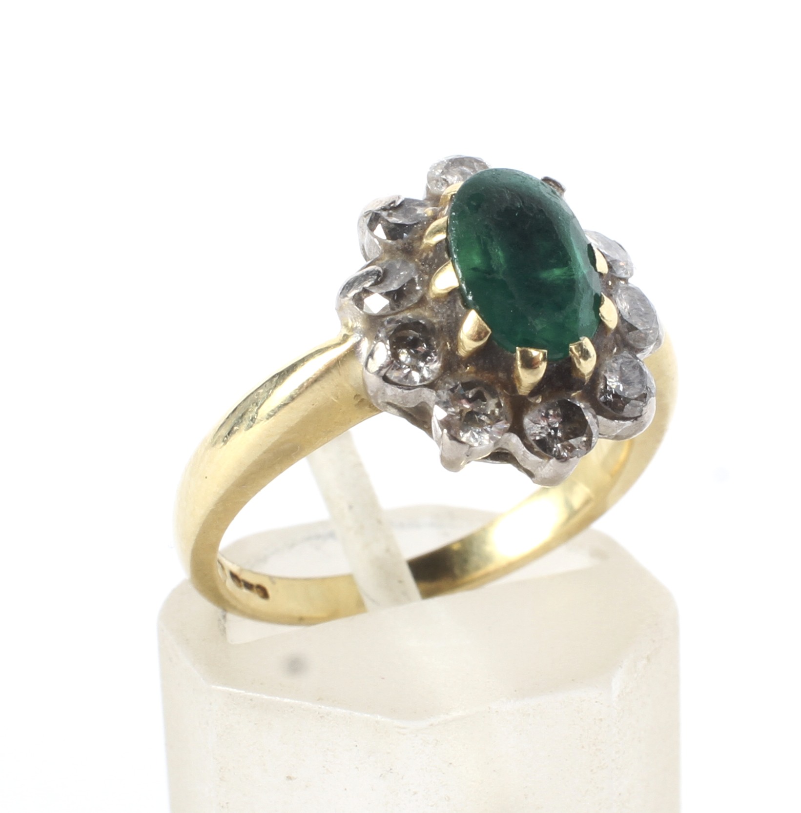 A modern 18ct gold, emerald and diamond oval cluster ring.