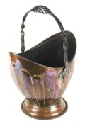 An early 20th century copper coal bucket with a decorative iron swing handle,