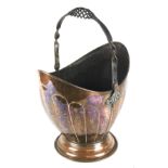 An early 20th century copper coal bucket with a decorative iron swing handle,