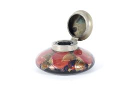 An early 20th century Moorcroft pewter-mounted pomegranate pattern inkwell.