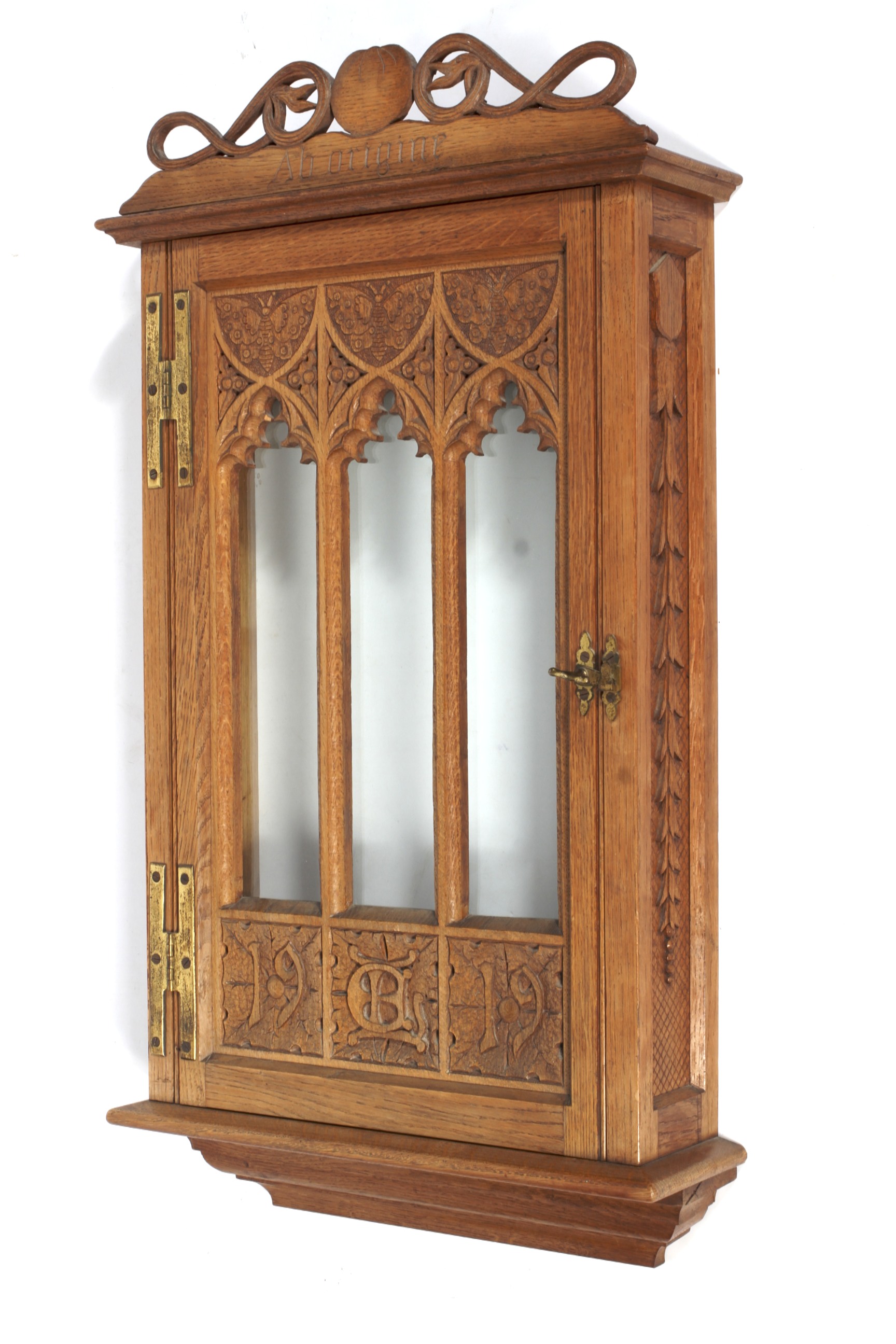 A Gothic style carved oak and glazed display cabinet, dated 1919.