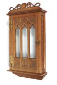 A Gothic style carved oak and glazed display cabinet, dated 1919.