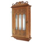 A Gothic style carved oak and glazed display cabinet, dated 1919.