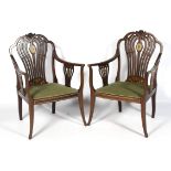 A fine pair of Edwardian inlaid Sheriton Revival elbow chairs.