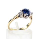 A modern 18ct gold, sapphire and diamond three stone ring.