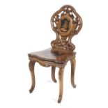 A late 19th century Black Forest carved marquetry and penwork musical chair.