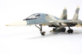 Two diecast military fighter jet aircraft models. An F-4 Phantom on stand and a Chinese MiG 29.