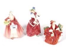 Three Royal Doulton figurines.