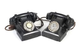 Two vintage rotary dial black Bakelite telephones.