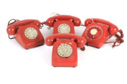 Four assorted red coloured rotary dial vintage telephones.