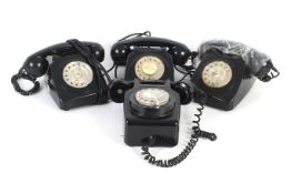 Four assorted black plastic rotary dial telephones.