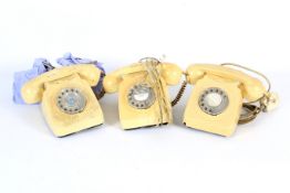 Three assorted cream coloured rotary dial telephones.