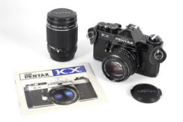 A Pentax KX 35mm SLR camera, black. With a 50mm 1:1.4 Pentax-M lens with front cap, a 135mm 1:2.