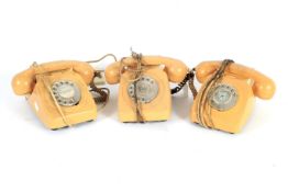 Three vintage cream coloured rotary dial telephones.