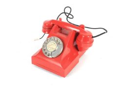 An ITI red rotary dial telephone.