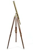 An adjustable Nauticalia London brass telescope on a wood and brass tripod support.