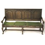 An oak panelled back settle. With arched