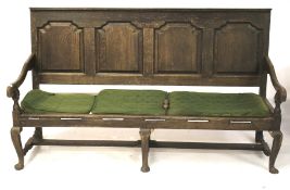 An oak panelled back settle. With arched