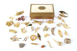 A collection of gilt metal brooches. Of