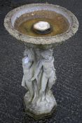 A stone bird bath, the bowl supported by the naked maidens on a plinth base, H84cm.