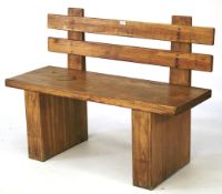 A vintage chestnut bench. The single plank seat attached to two block supports,