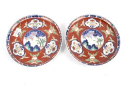 A pair of Chinese Imari plates with central pictorial plaque and 6 character marks to the base