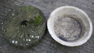 A vintage mill stone, Diam 61cm, and stone water bowl, Diam 57cm, used as a garden water feature.
