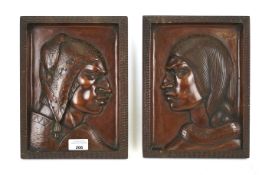 A pair of carved wooden panels by Roberto Guitierrez.