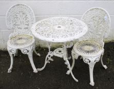 A vintage cast metal garden table and two chairs.