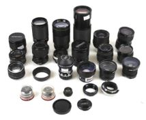 A large collection of camera and enlarger lenses, mostly Minolta and Canon fitment.