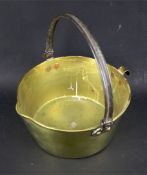 A brass preserve pan with iron handle.