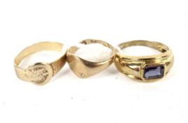 Three 9ct gold rings. Comprising a signet ring, a buckle ring and a ring set with a red stone,